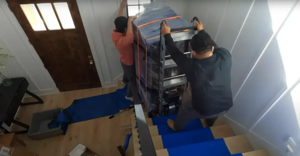 Apartment Movers 13 Two movers carrying a padded dresser down a staircase